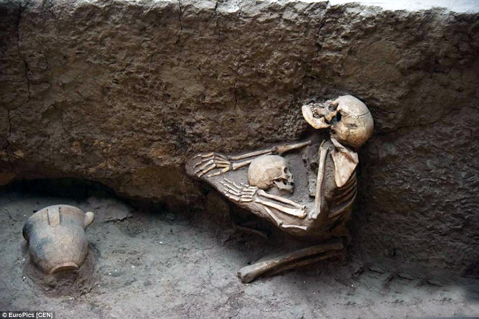 Heartbreaking: Skeletal remains show the mother kneeling down on the ground with her arms around her son in central China