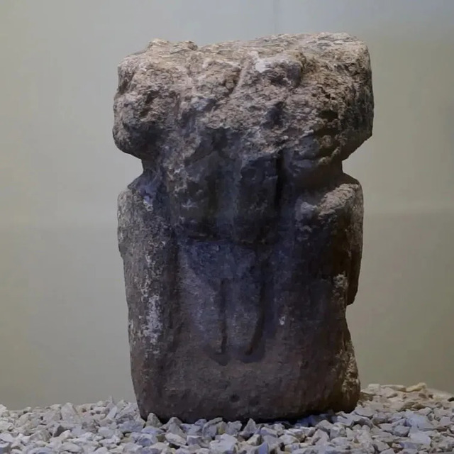 The backside of the anthropomorphic statue from Göbeklitepe, highlighting its detailed carving and weathered texture.