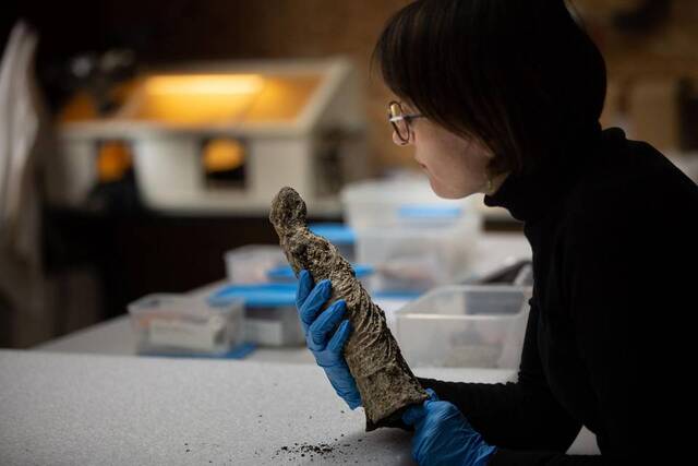 A conservationist carefully examines one of the Roman artifacts unearthed during the excavation, highlighting the intricate craftsmanship of the ancient pieces. Credit: Renaud Bernadet, Inrap.