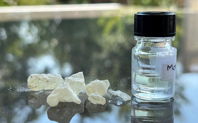 Dammar resin, a key ingredient used in ancient embalming practices, is displayed alongside a bottle of the recreated "scent of eternity" by perfumer Carole Calvez, crafted from scientific analyses. (Credit: Barbara Huber)