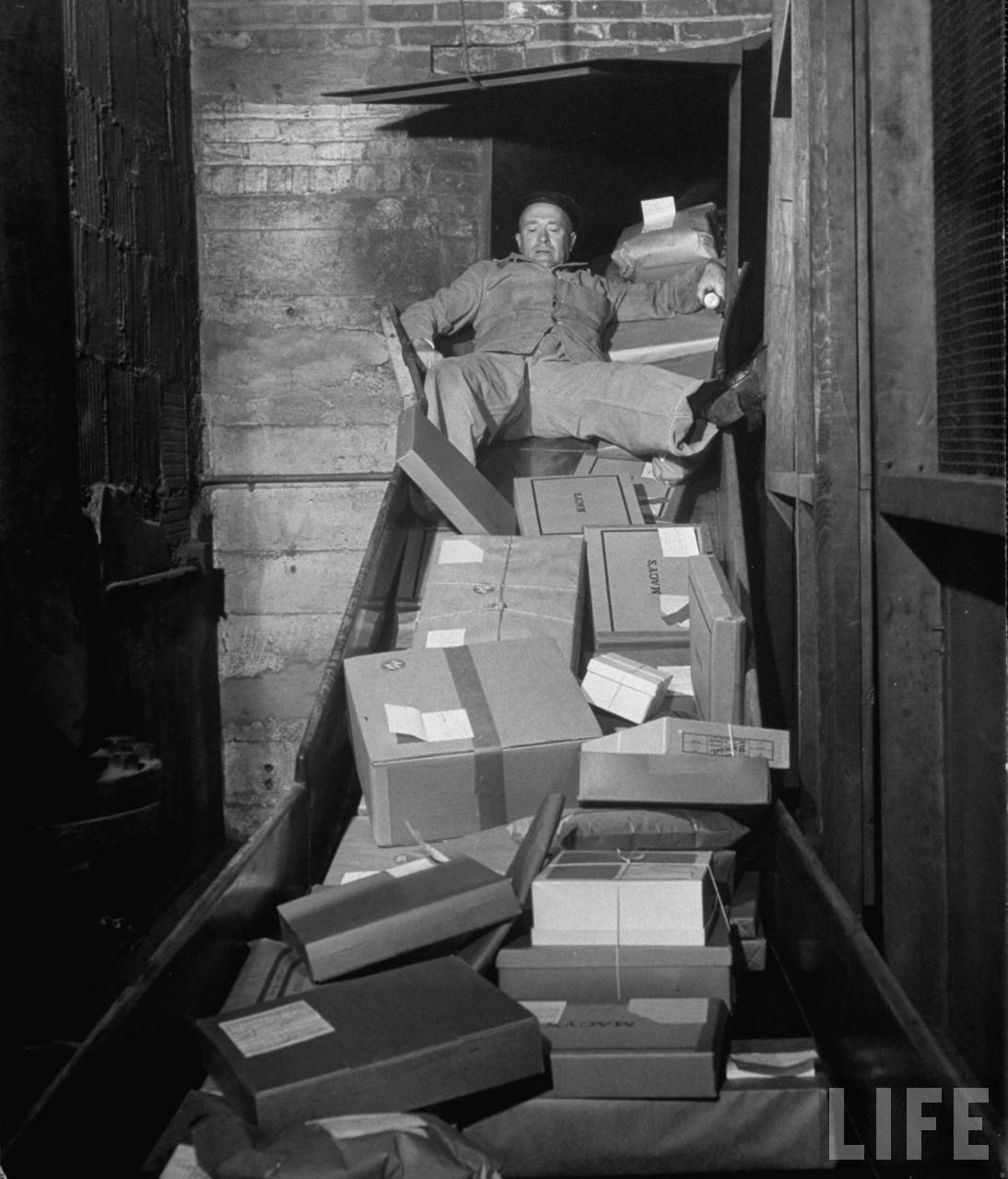 A Macy’s employee clears the package chute, managing a busy day in 1948.