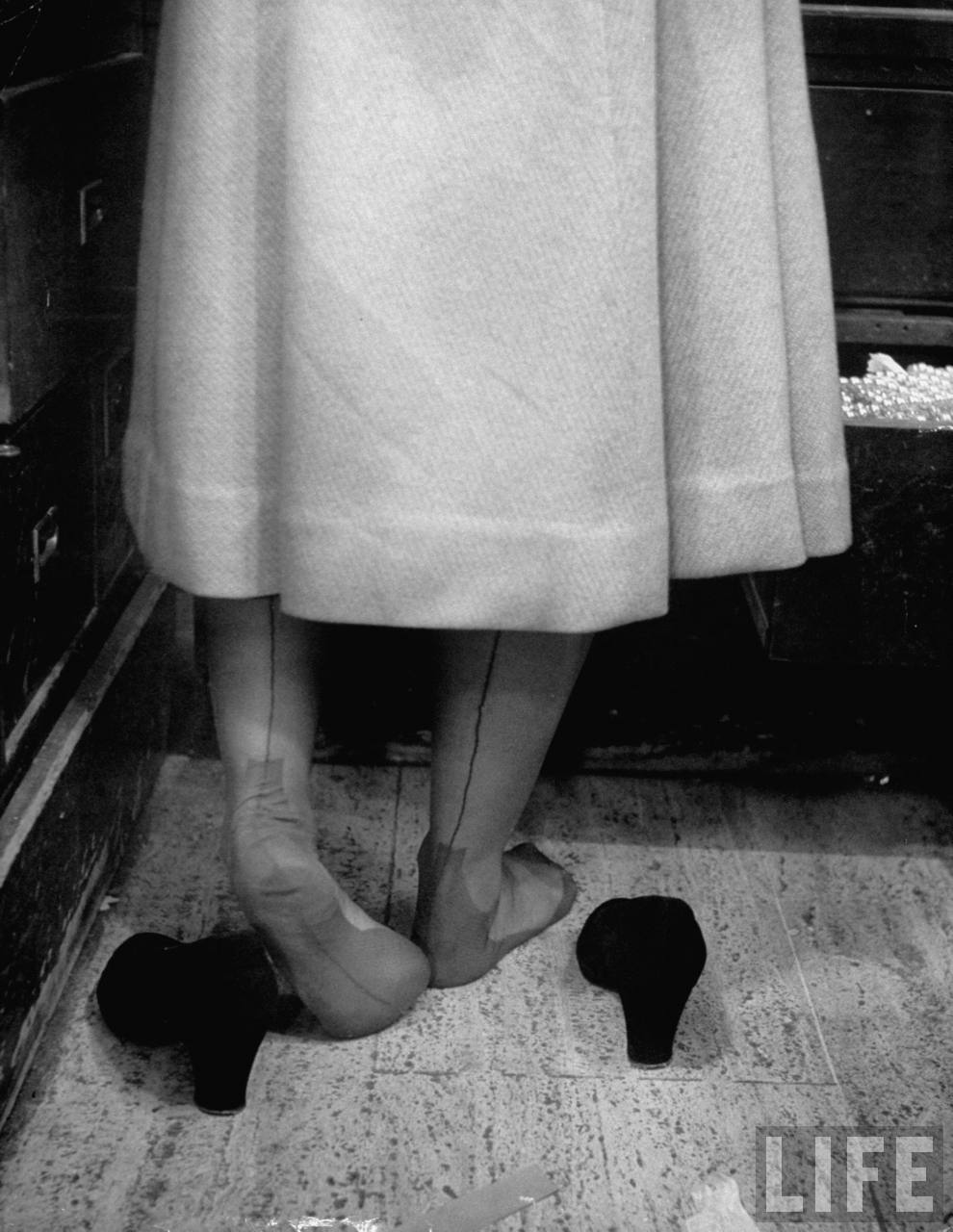 A Macy’s employee tries on shoes in 1948, testing the new merchandise.
