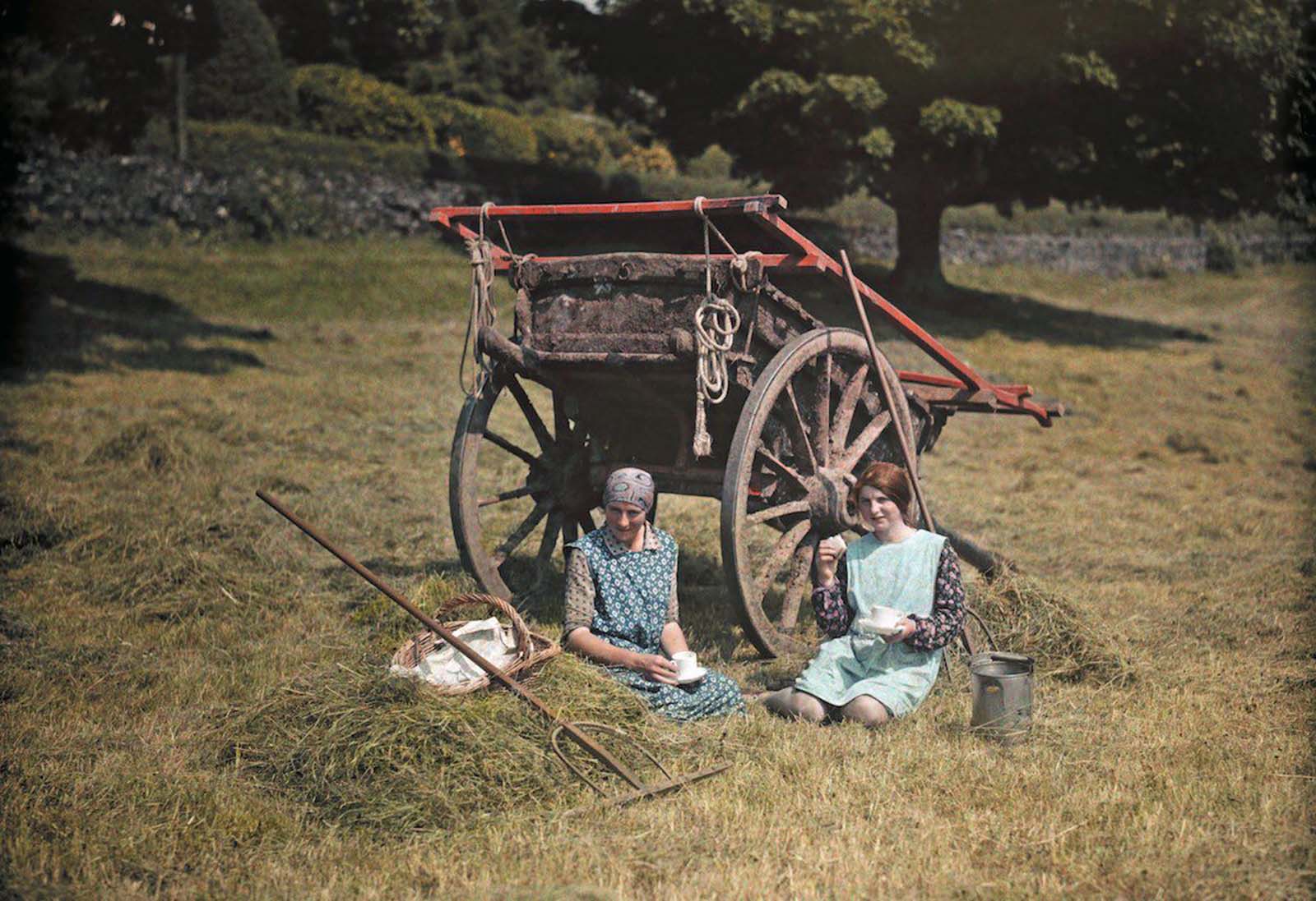 A Moment of Rest – Two hardworking women take a break for lunch in a lush Lancashire hayfield.