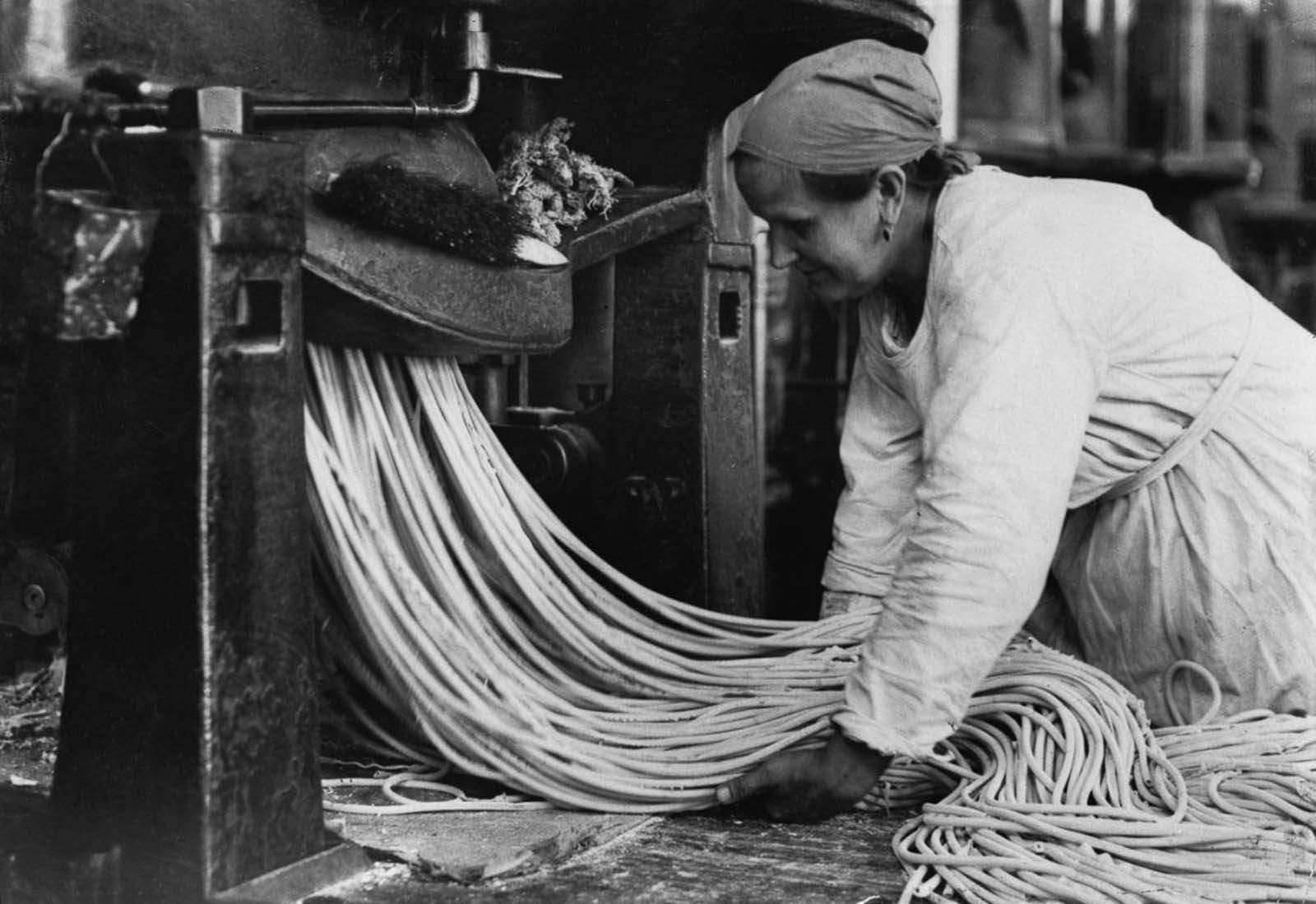 A Russian factory worker carefully handles long strands of pasta. Date unknown.
