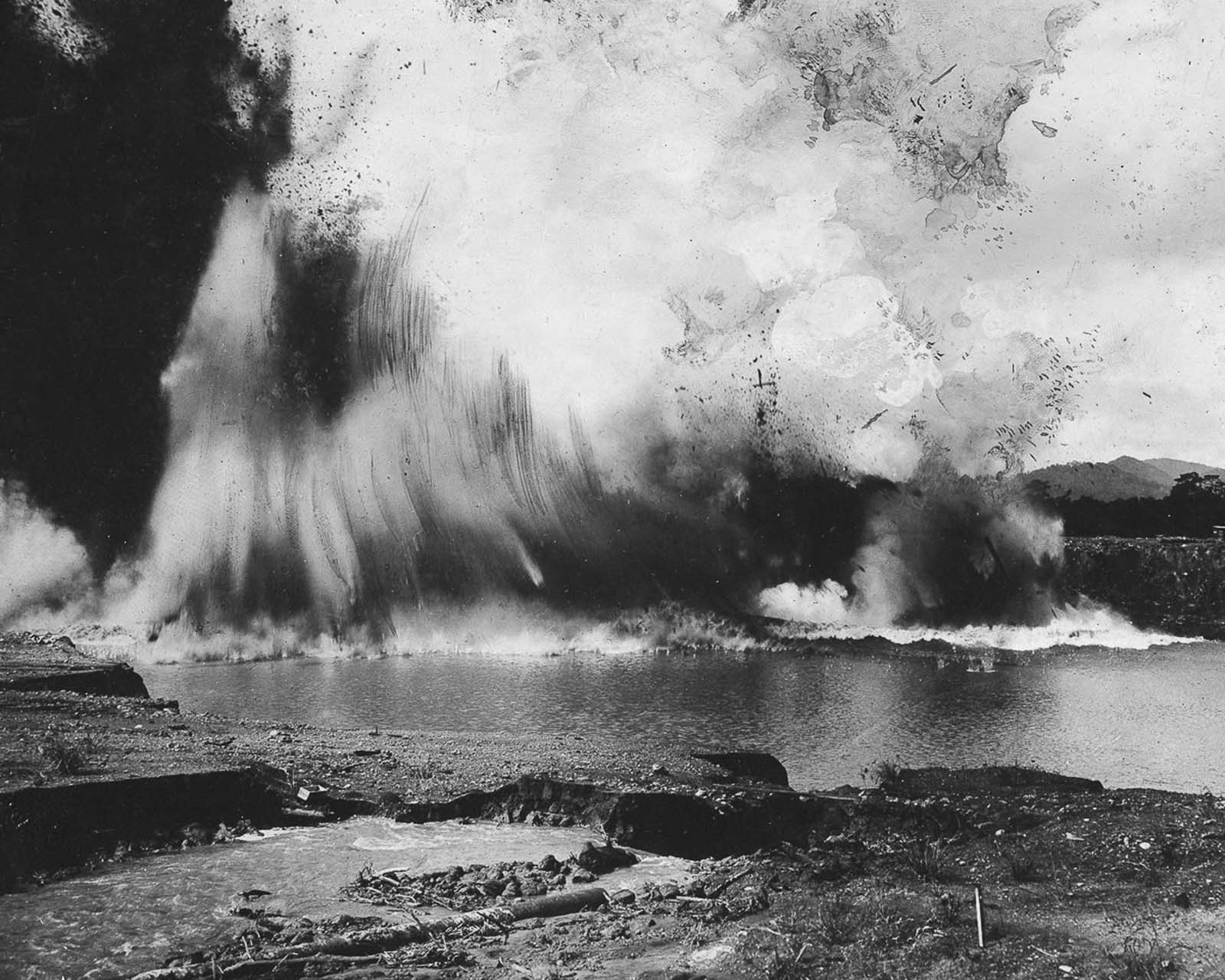 A historic blast clears the final barrier, as the dike separating the canal from the Atlantic is demolished in 1913.