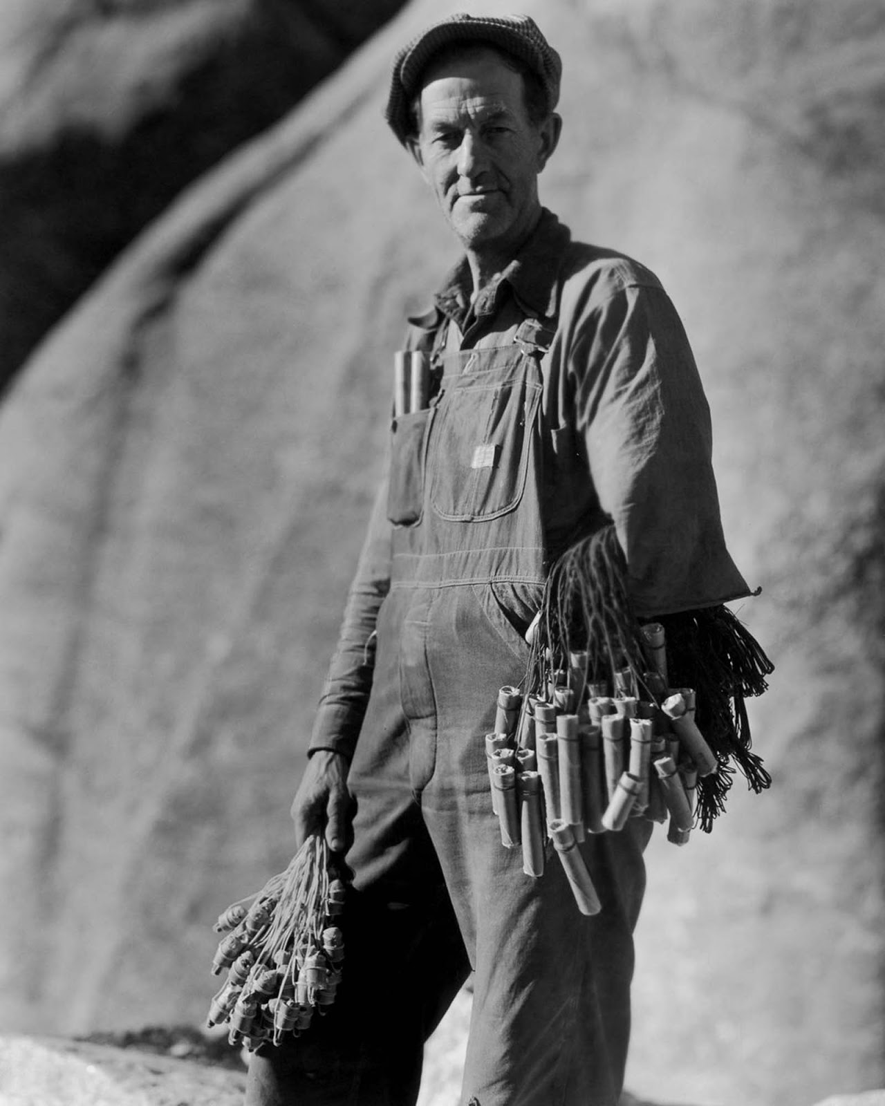 A “powder monkey” handles dynamite charges and detonators, 1930.