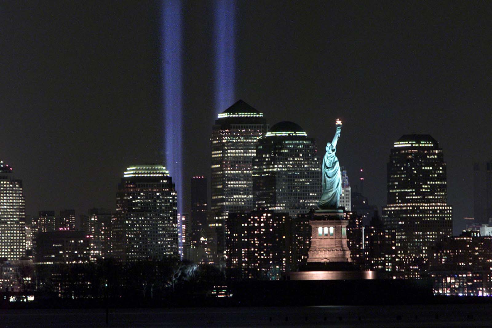 A powerful image from March 11, 2002—The "Tribute in Light" memorial beams behind the Statue of Liberty, honoring those lost on 9/11.