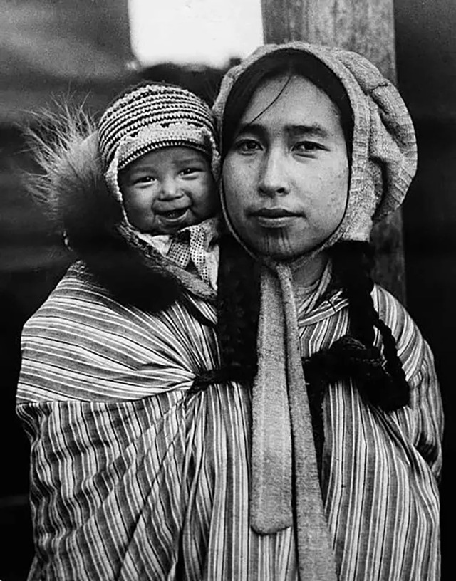 An Inuit mother cradles her child in Cape Prince of Wales, Alaska, photographed in 1927.