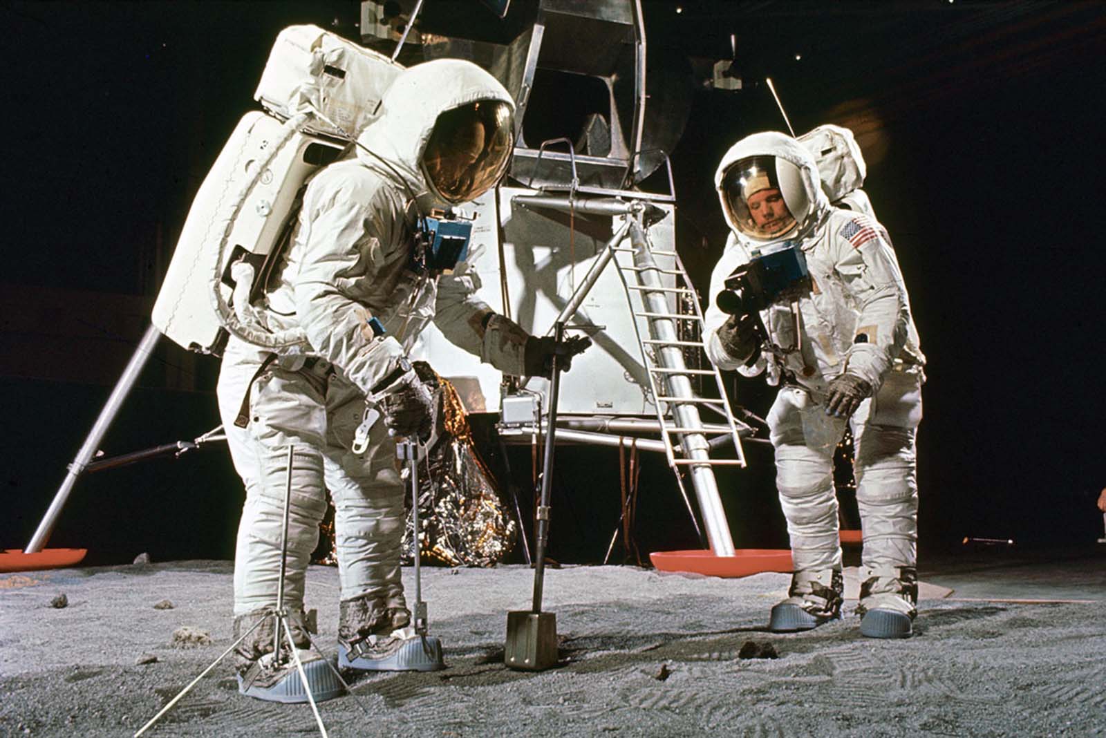 Buzz Aldrin and Neil Armstrong practice sample collection techniques near a lunar lander mock-up, spring 1969.