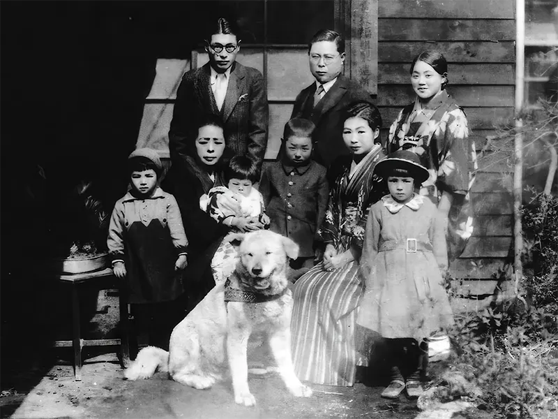 Hachikō with an unknown family, a moment of warmth shared beyond his legendary loyalty.