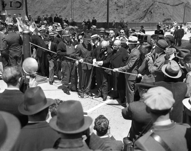 Mayor Rossi, donned in goggles, cuts through the chain with a small blowtorch while the waiting crowd watches in anticipation. Remarkably, not a single person seems to be checking the time. (Photographer Unknown/San Francisco Chronicle via Getty Images)