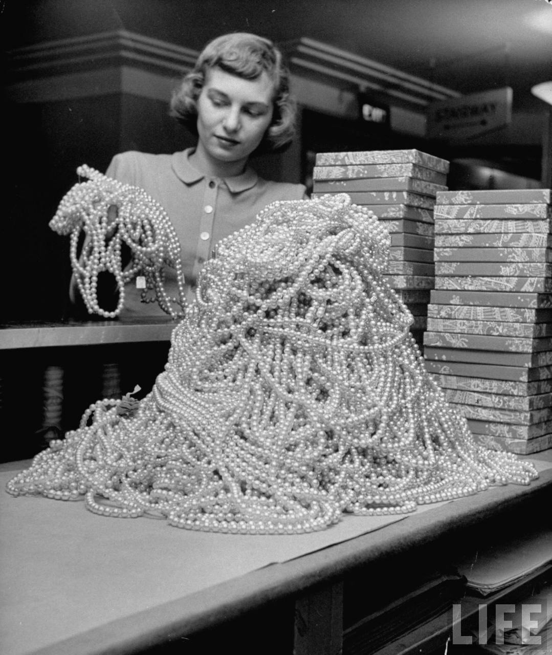 Macy’s employee Janet Steurer meticulously sorts through a stack of costume pearl necklaces, ready to sell them that very day.