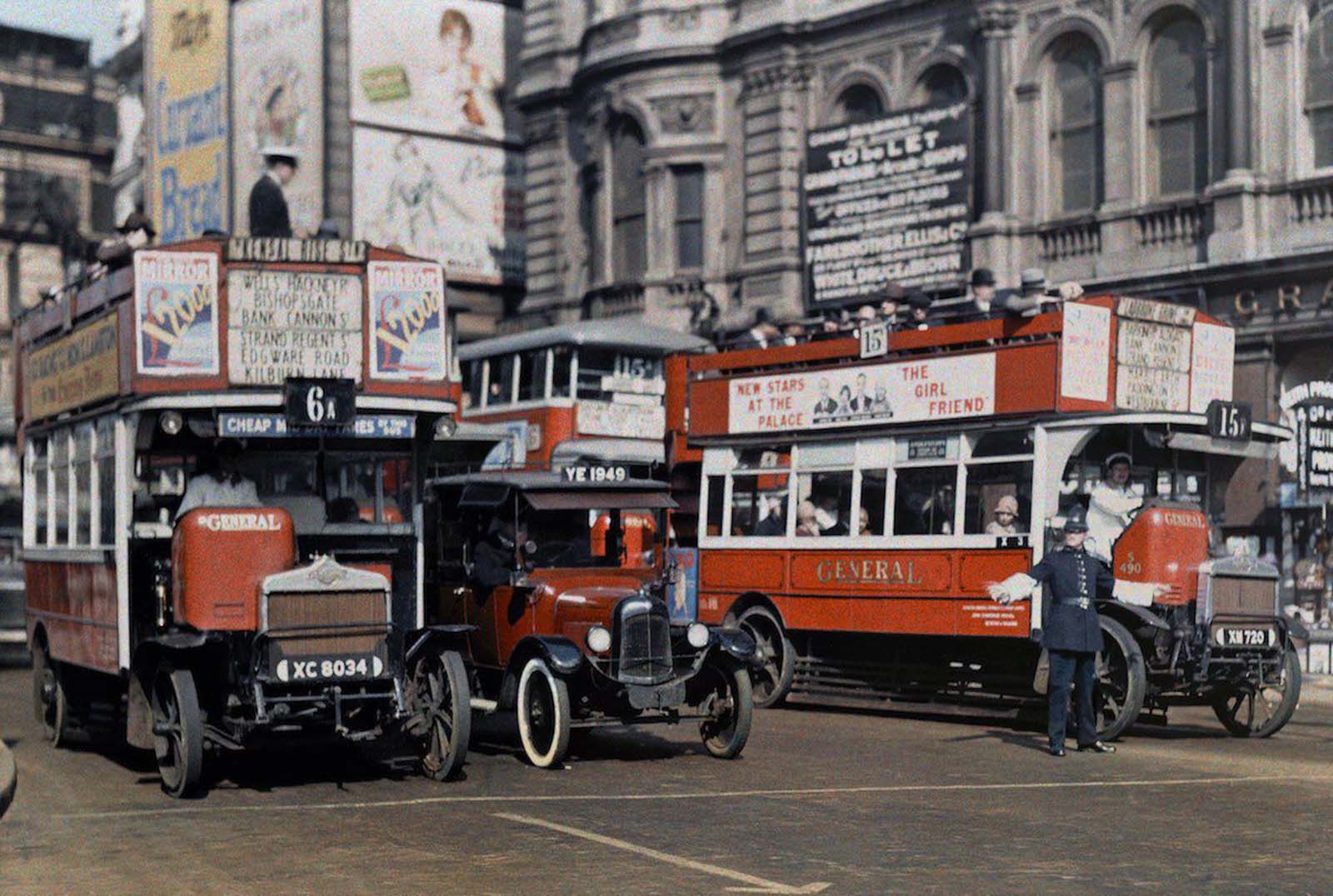 Navigating Trafalgar Square – A London policeman expertly directs buses through the bustling intersection of Trafalgar Square.