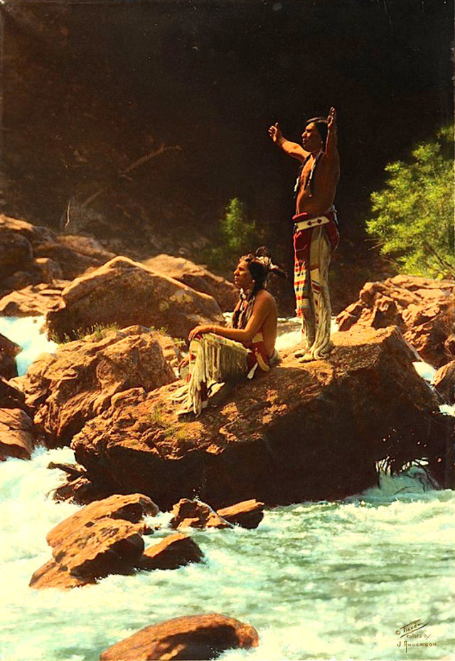 Piegan men offering prayers to the Thunderbird along a Montana river, a powerful spiritual moment captured in 1912 by Roland W. Reed.