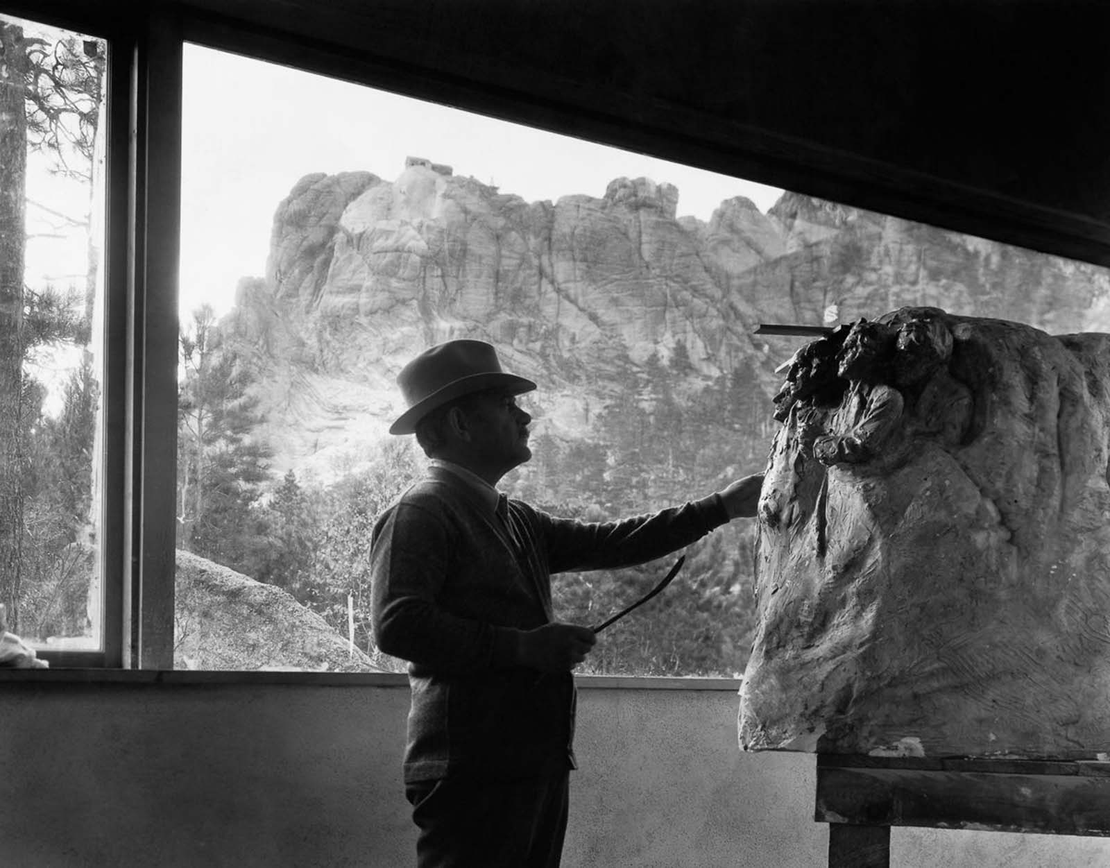 Project leader Gutzon Borglum reviews a scale model in his studio beneath Mount Rushmore, 1930.