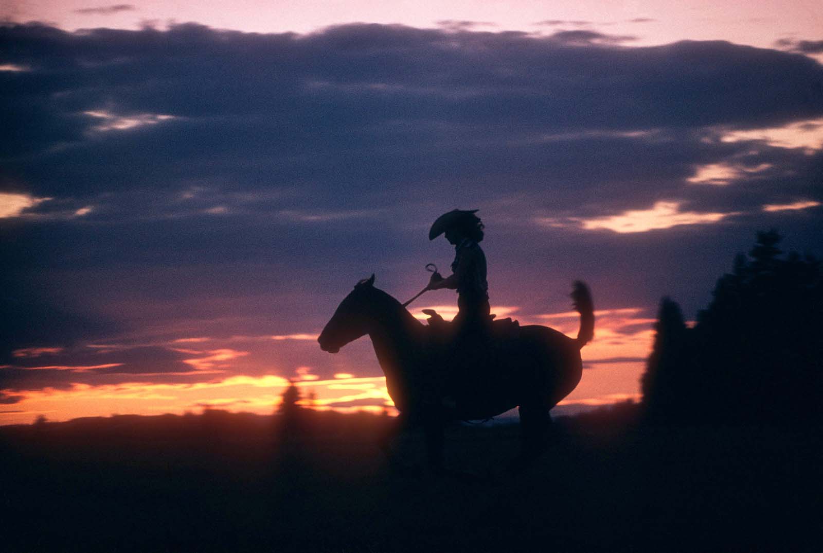 Riding into the horizon – A lone cowgirl gallops under the Oregon sunset, 1958.