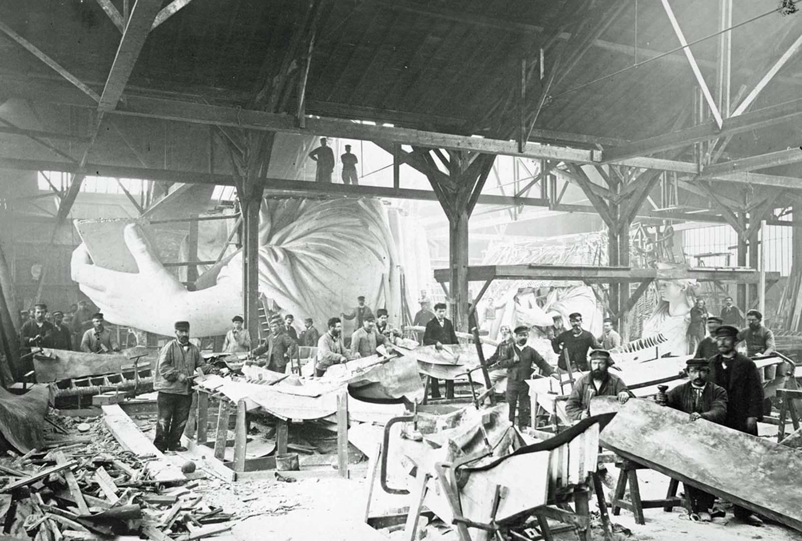 Skilled craftsmen hammer sheets of copper in a Paris workshop, shaping the future Statue of Liberty in 1883.