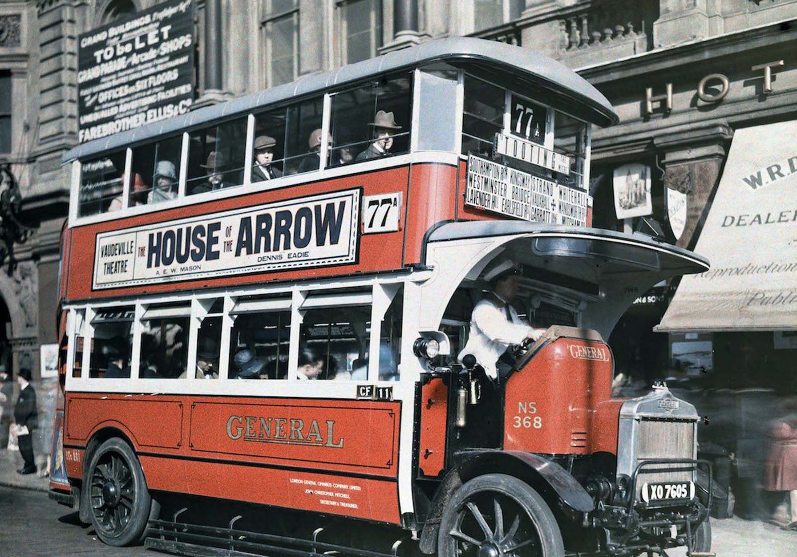The Iconic Double-Decker – A red London bus pauses to let passengers aboard, a timeless scene in the city.