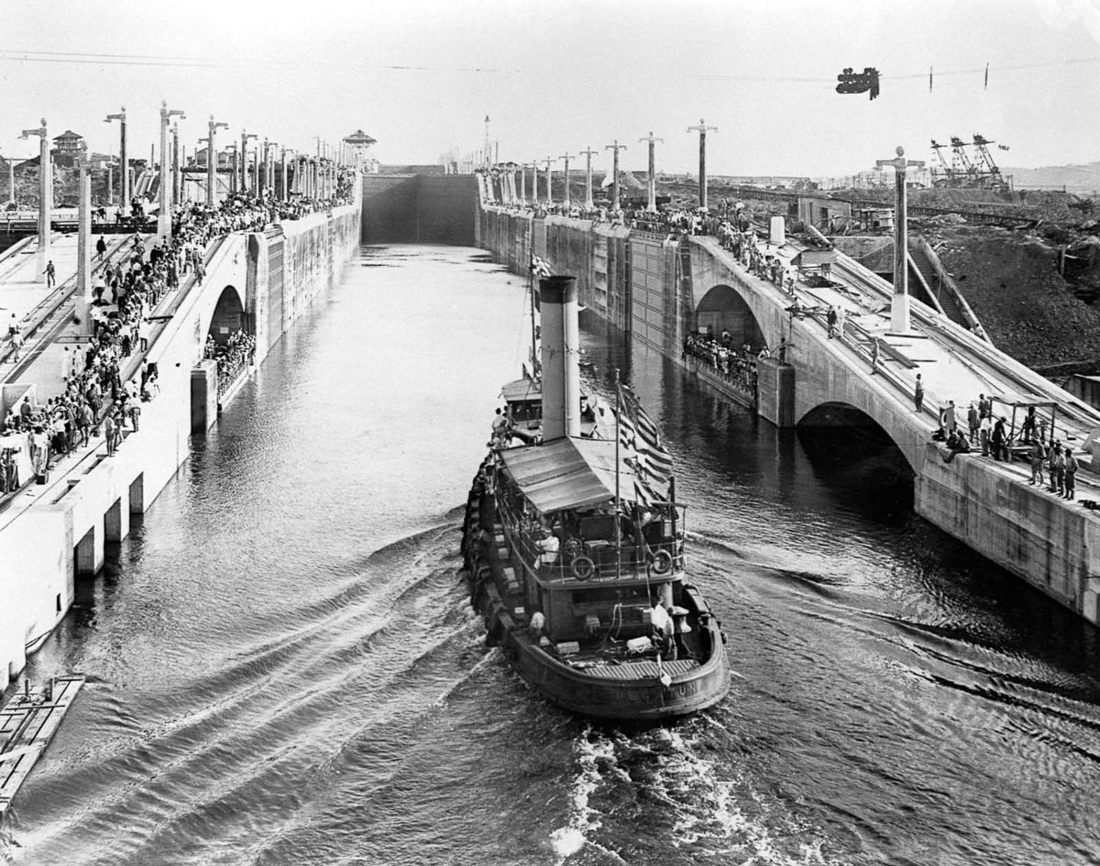 The U.S. tugboat Gatun makes history, becoming the first vessel to pass through the completed locks in 1913.