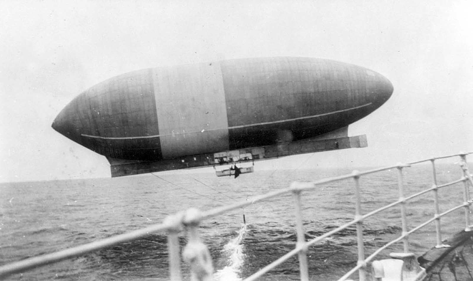 The Wellman airship "America," seen from the RMS Trent, drags its anchor across the water, circa 1910.