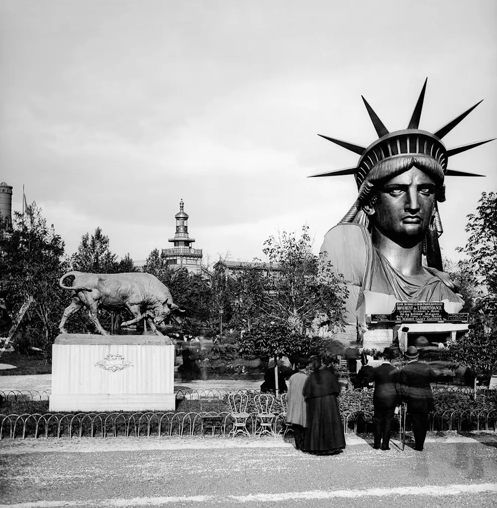 The iconic head of the Statue of Liberty showcased at the Paris World’s Fair, drawing crowds before its assembly in New York.