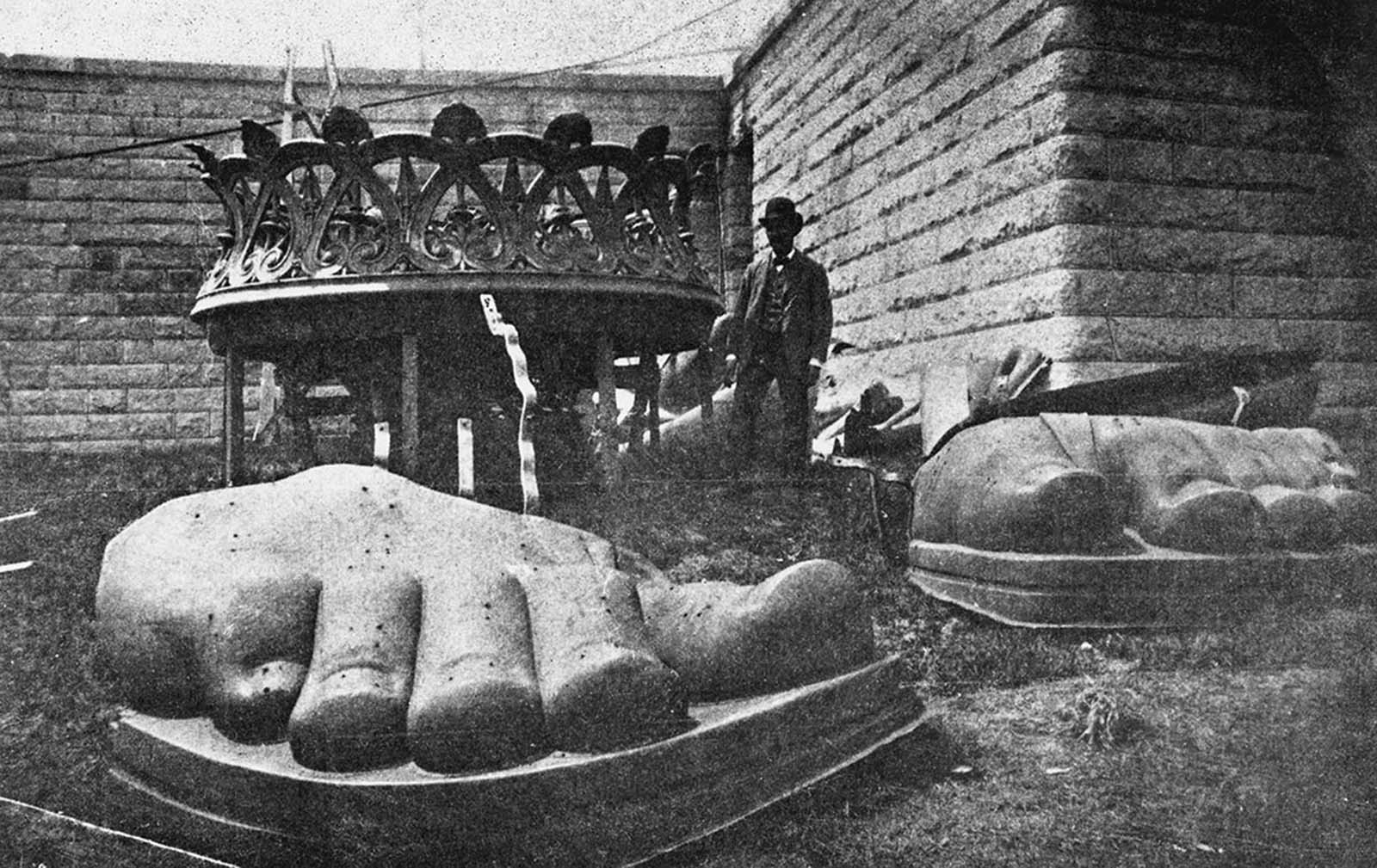 The monumental task of assembling the statue begins—here, the toes and base of the torch lie on the ground, ready to be hoisted onto the pedestal on Bedloe’s Island, circa 1885.