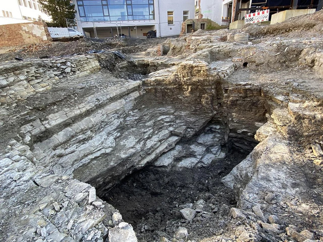 The quarry in its depths, uncovered by archaeologists, showing layers of rock that were once used for construction in the town.