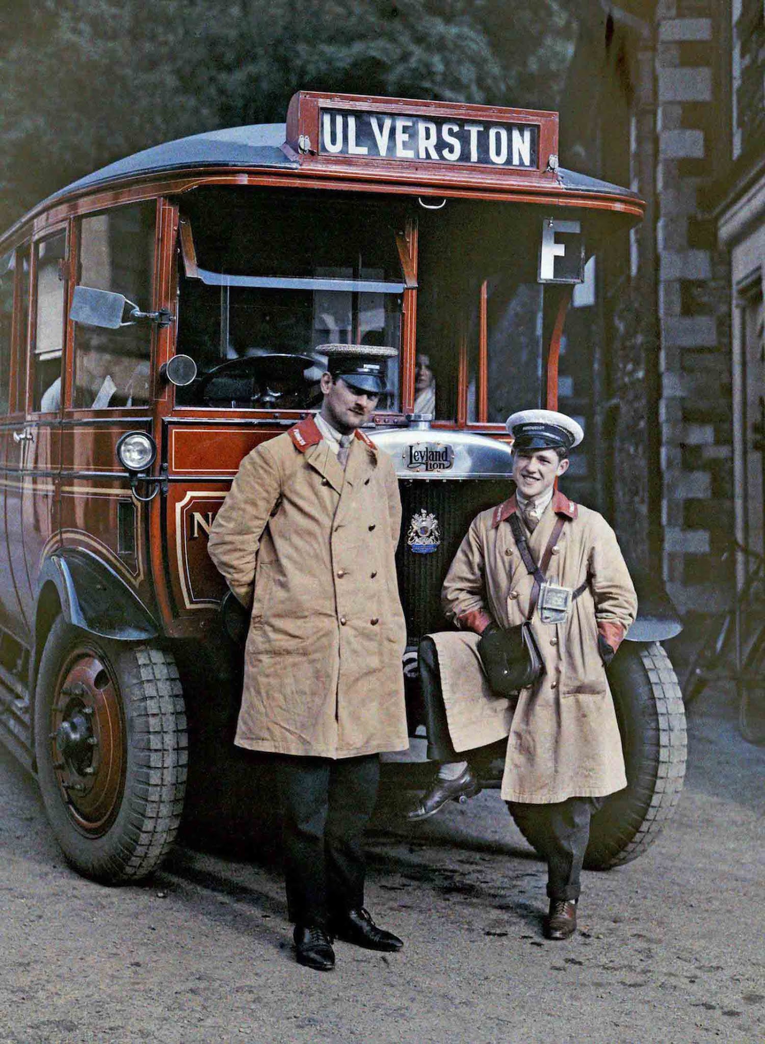 Touring the English Countryside – Two proud bus drivers pose in front of their tour bus in Ulverston, Cumbria.