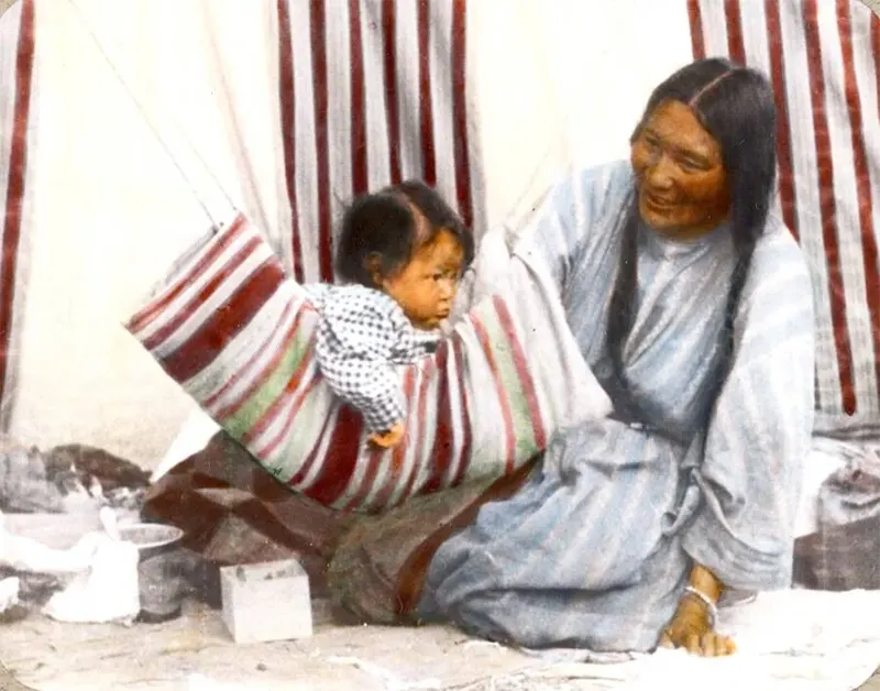 Walks-In-The-Water (Soya-wa-awachkai) and her baby Koumiski (Round Face), members of the Siksika Nation. Montana, early 1900s.