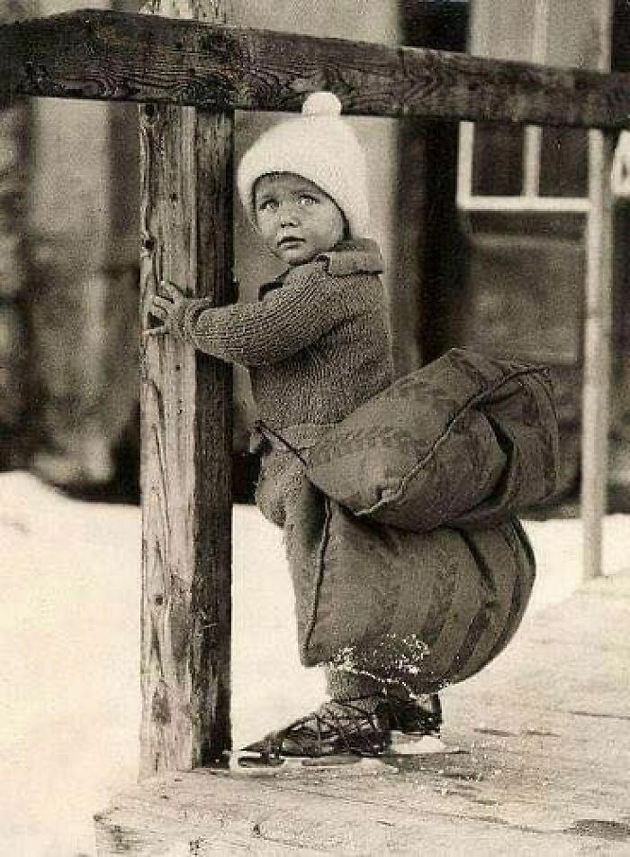 A Dutch boy with a pillow strapped to his backside for protection while skating on ice, 1933.