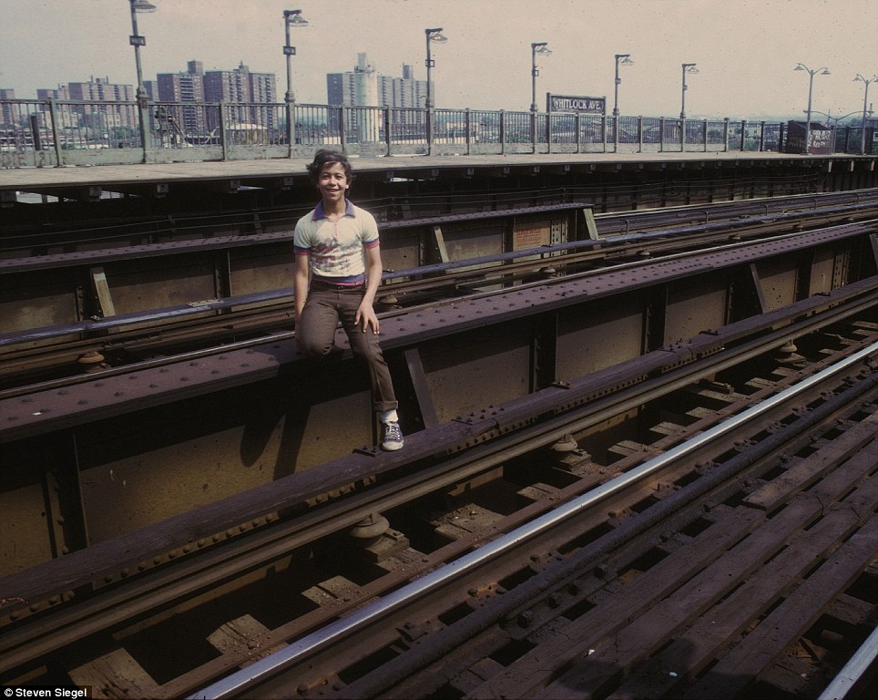 A daredevil kid poses dangerously on the subway tracks at Whitlock Ave station, precariously close to the infamous third rail.