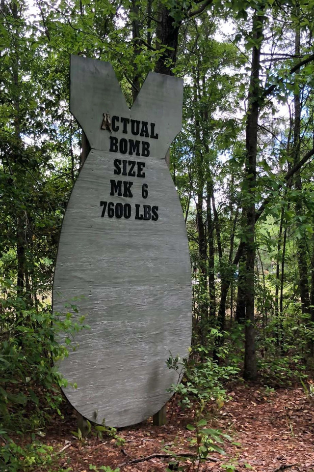 A homemade marker stands at the site in Florence, South Carolina, where a Mark 6 nuclear bomb was dropped in 1958, causing injuries and destruction, including a 35-foot-deep crater.
