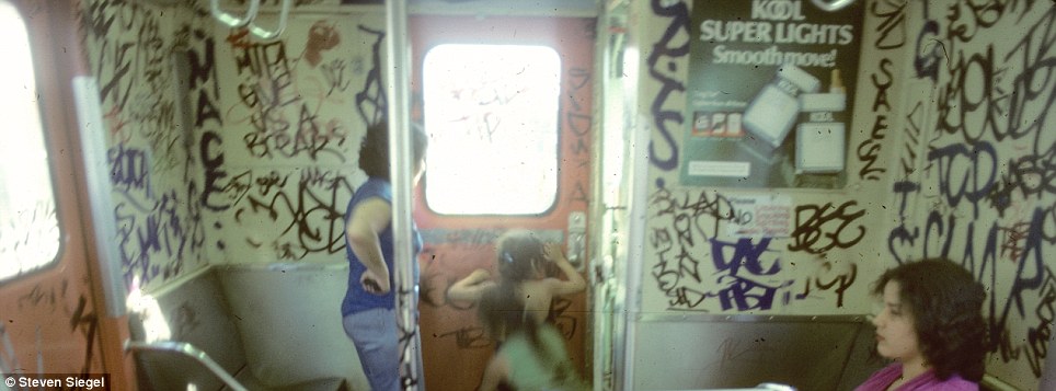 A nostalgic moment as a woman and two girls peek out, while a cigarette ad remains untouched by the graffiti that once overtook the subway.