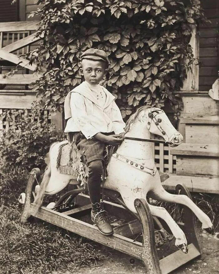 A portrait of a boy enjoying a ride on his rocking horse, 1902.