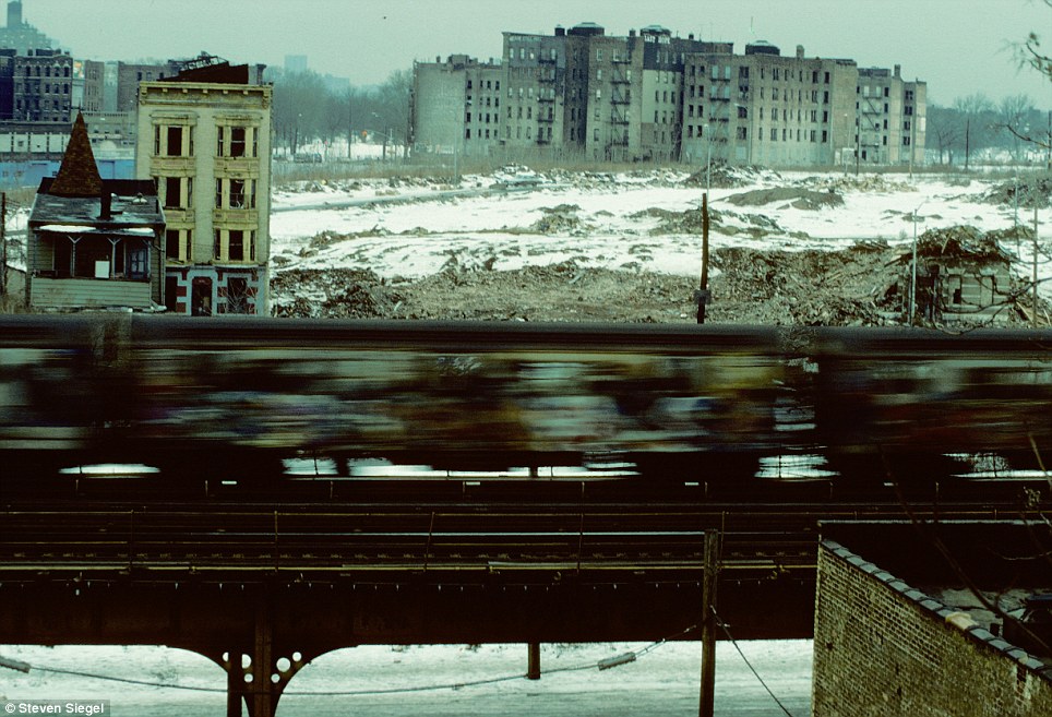 A snow-covered South Bronx landscape serves as the backdrop for a speeding train, its metallic body slicing through the wintry scene.