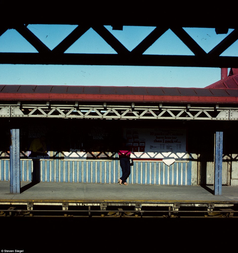 A solitary passenger waits on an empty subway platform, half of their figure swallowed by shadow in this haunting scene.