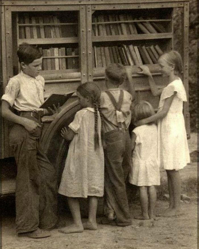 Barefoot children by a mobile book cart in the Appalachian Mountains.
