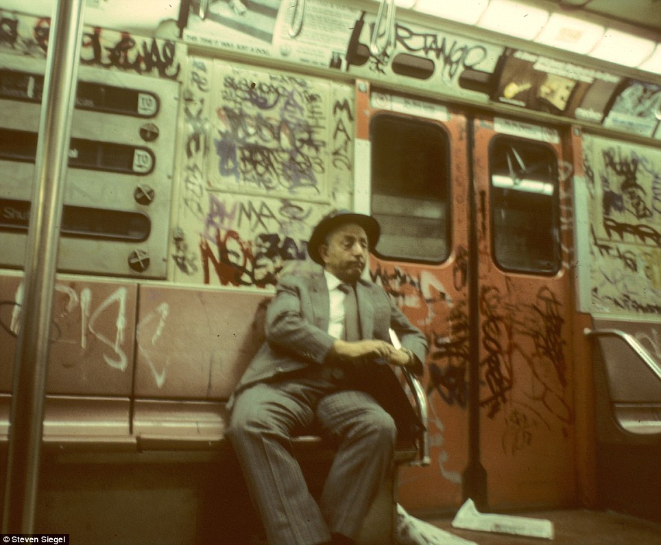 The rhythmic hum of the train has lulled this well-dressed man to sleep on the gritty subway, his fallen newspapers scattered across the floor.